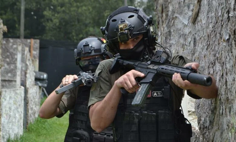 Two airsoft players moving along a wall