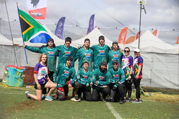 South African team and staff posing together with the flag