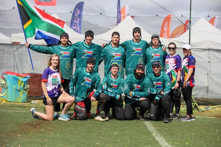 South African team and staff in a group photo with the flag